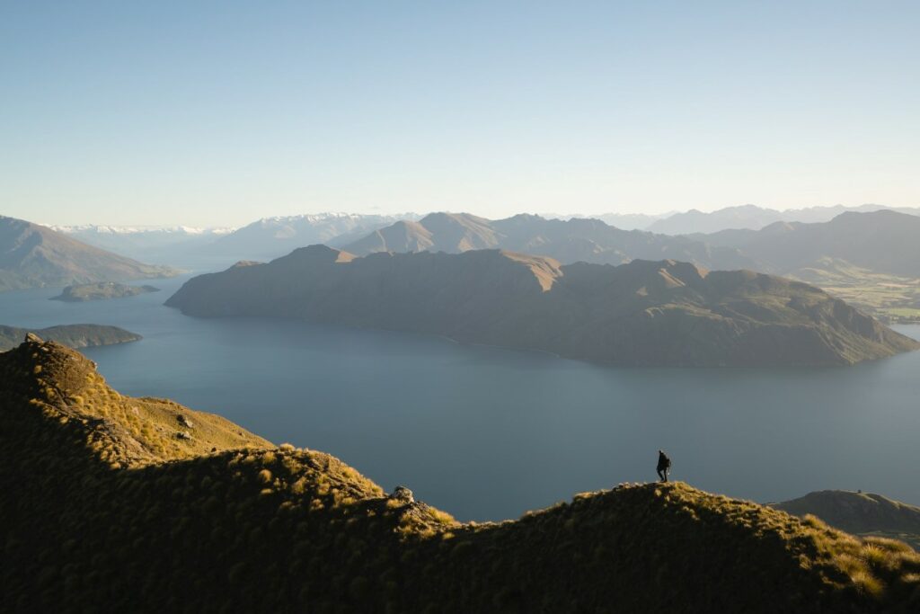 homme qui randonne en face d'un lac
